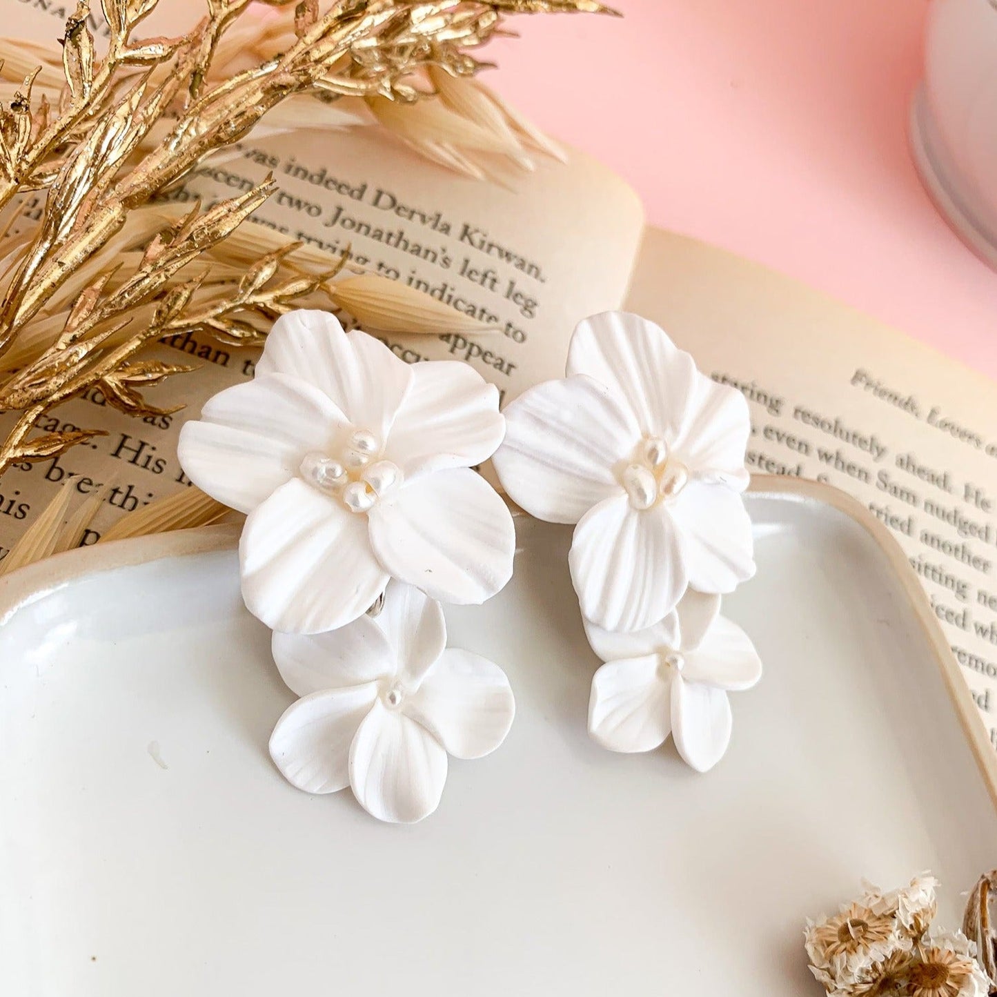 Bengelende oorbellen met witte bloemen en kleine pareltjes in het midden
