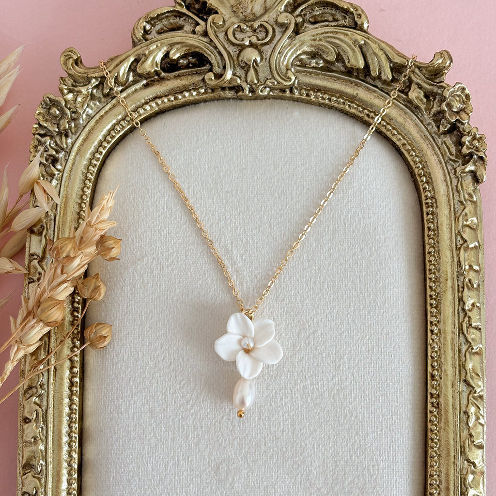 This is a Dainty necklace handmade with a white flower pendant in polymer clay with a tiny pearl in the center and a pearl drop.