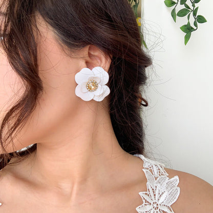 bride wearing the white flower earrings in clay