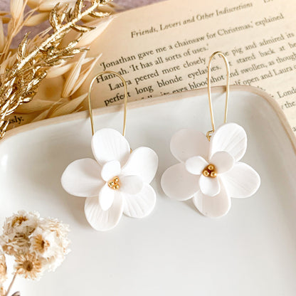 white flower dangly earrings with gold stainless steel beads in the center