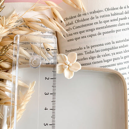 ivory flower clay earrings measured with a ruler. 