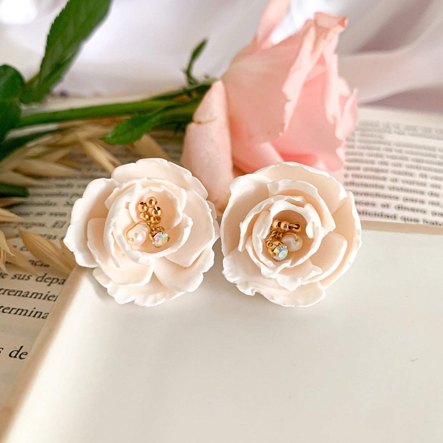 ivory flower stud earrings witn pearls and beads wrapped in wire in the center