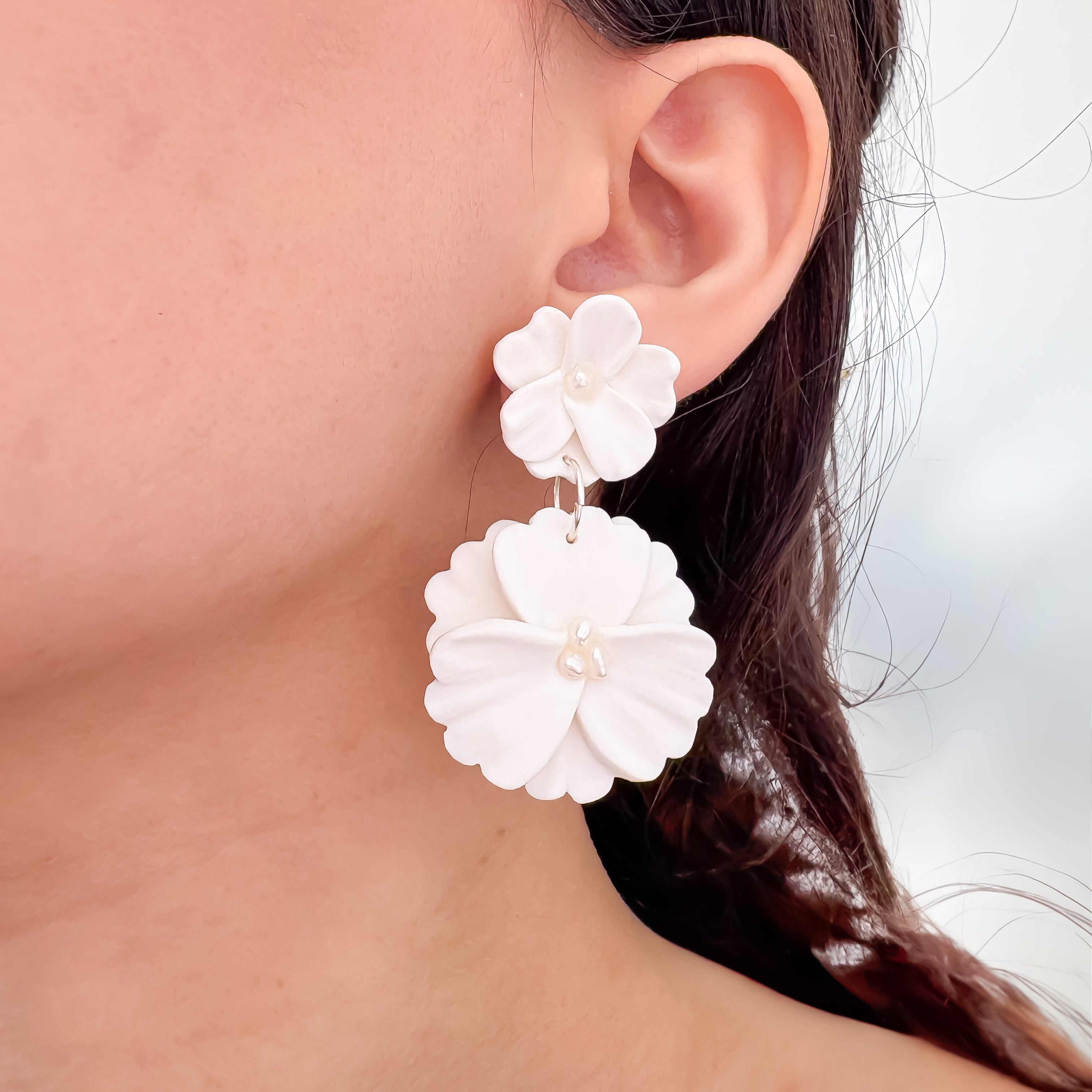 bruid draagt dubbele bloemenoorbellen